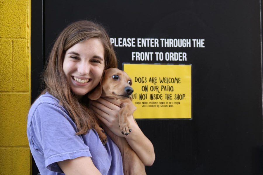 Gracie Jones junior, cuddles with her dog Tex on the porch of Melt Ice Cream.