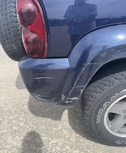 A scratched car in the student parking lot.