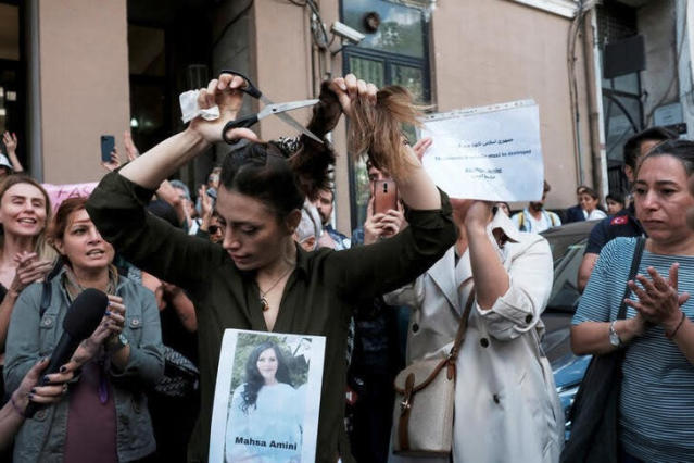 Nasibe Samsaei, an Iranian woman living in Turkey, cuts her hair during a protest/Getty Images