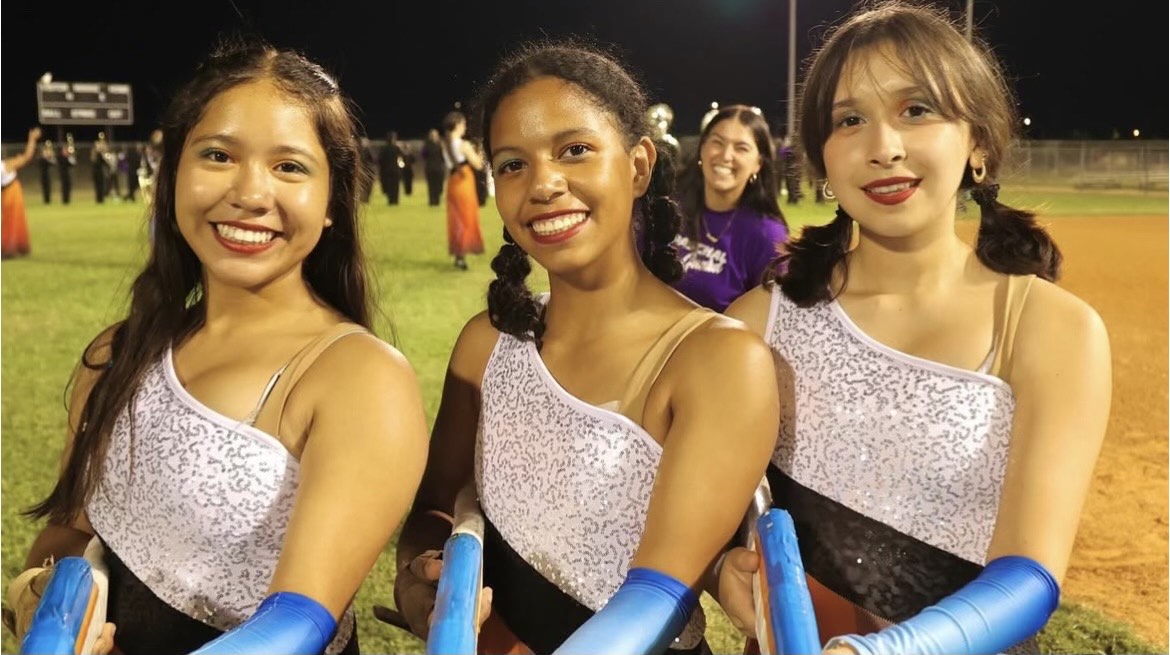 Color guard members left Jennifer Olea (12th) , middle Andrea Saddler (11th) , and right Ashley Saldivar (11th)